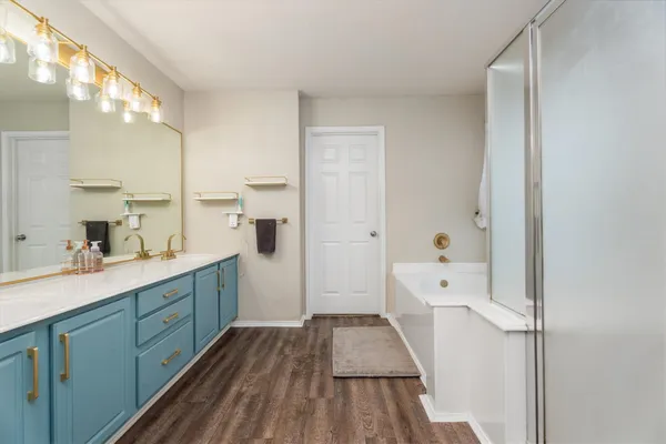 a spacious bathroom with a sink a large mirror and shower