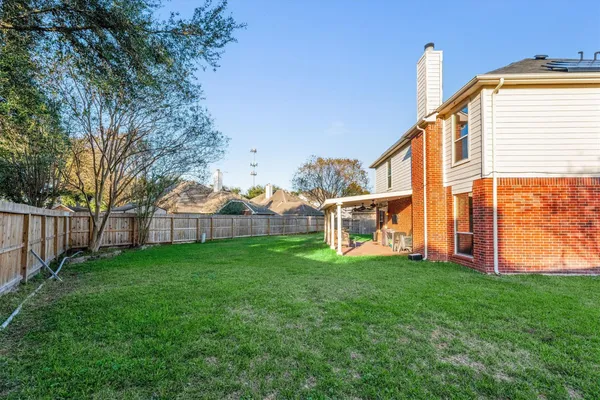 a view of an house with backyard and a tree