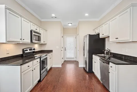 a kitchen with stainless steel appliances a refrigerator a stove a sink and a hard wood floor