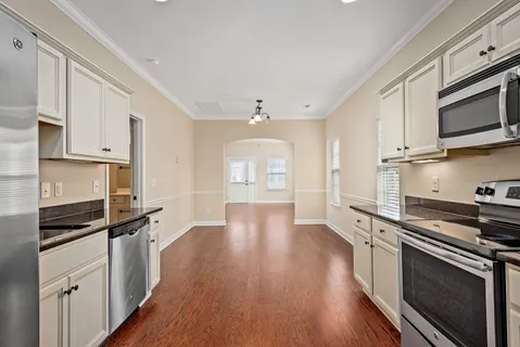 a kitchen with stainless steel appliances a stove cabinets and wooden floor