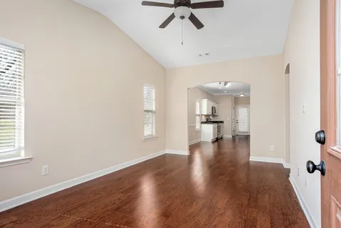 a view of a hallway with wooden floor and a cabinet