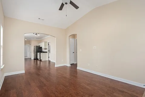 a view of empty room with wooden floor