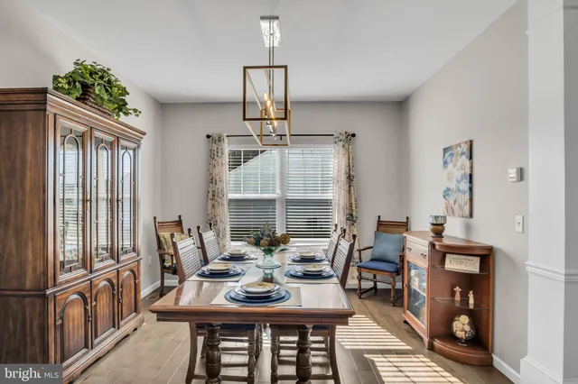 a kitchen with stainless steel appliances granite countertop a refrigerator a sink dishwasher a stove and white cabinets with wooden floor