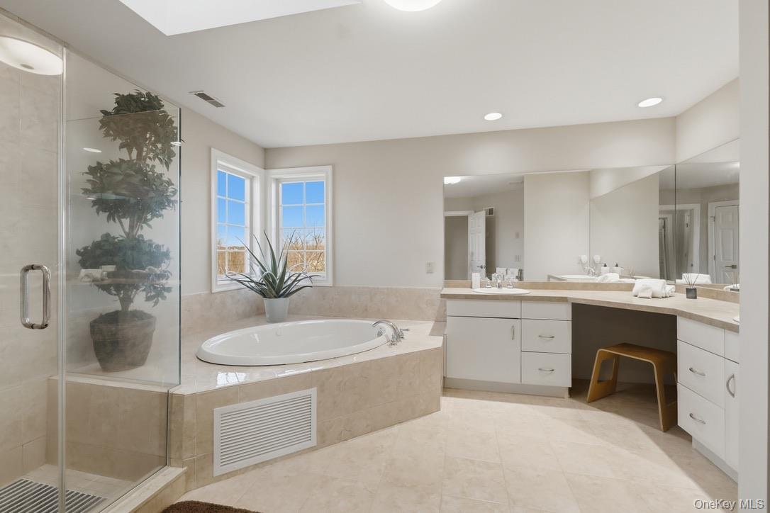 12 Feagles Road Warwick, NY 10990 - Photo 31 of 45 a bathroom with a sink a bathtub a mirror a vanity and a shower