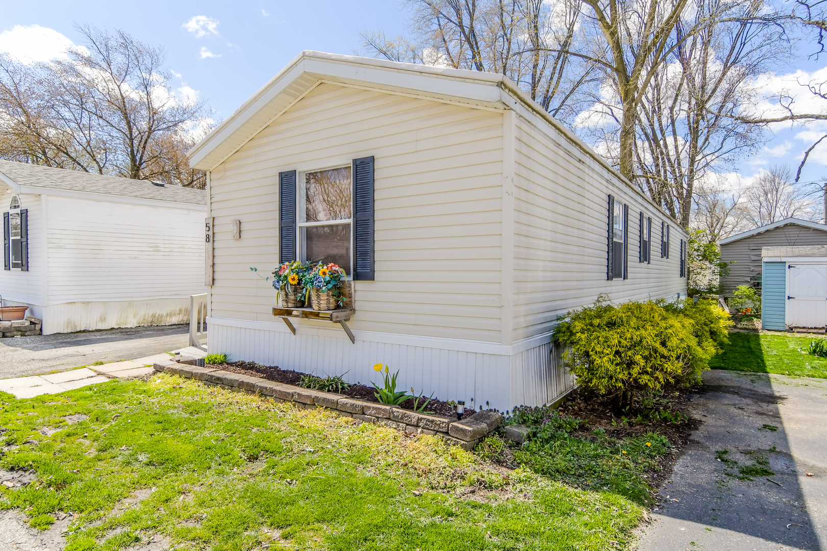 58 Oak Street Minooka, IL 60447 - Photo 3 of 28 a white house with a yard and a flower garden