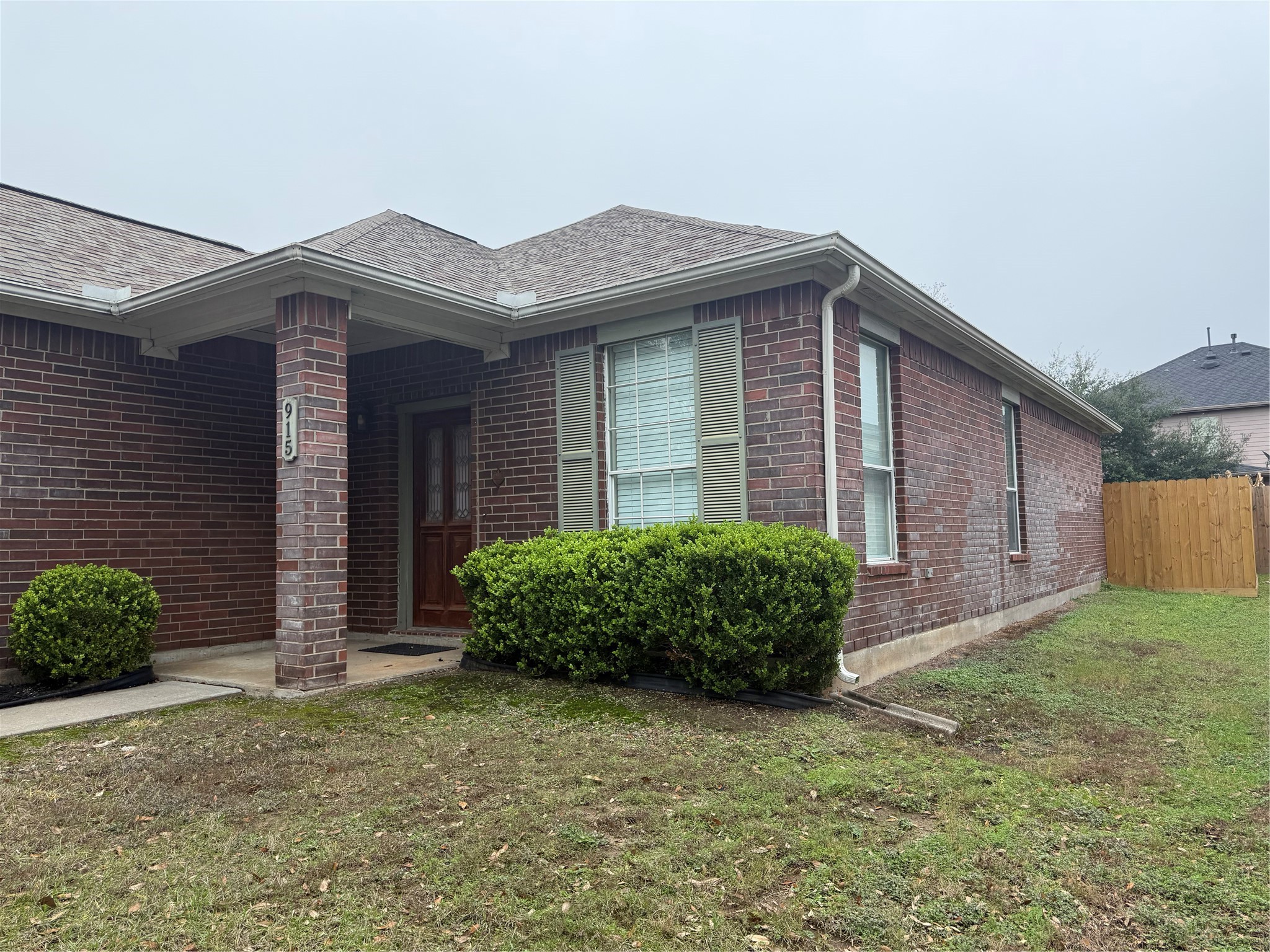 915 Saginaw Bay Court Spring, TX 77373 - Photo 2 of 15 This photo shows a single-story brick home with a covered front porch. It features neat landscaping with bushes and a small lawn, and a wooden fence enclosing the backyard. The house has a classic, inviting appearance.