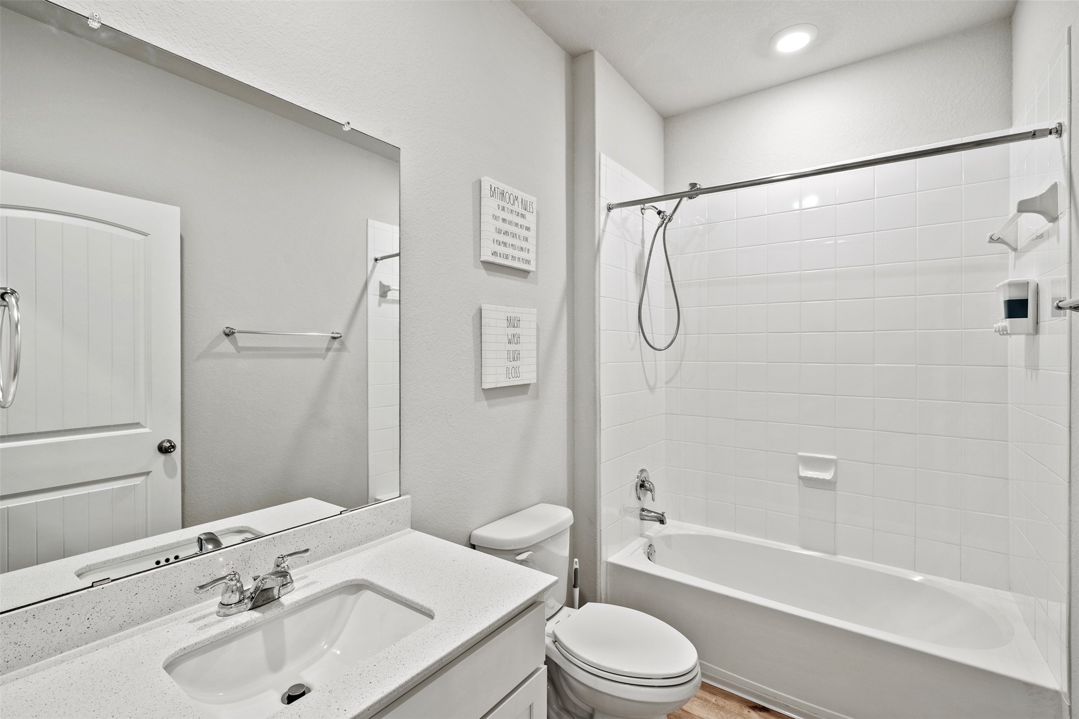 120 Ellinger Road Georgetown, TX 78626 - Photo 17 of 28 Bathroom featuring a vanity with an integrated sink and light-colored countertop, chrome faucet hardware, a full-width mirror, a white toilet, and a bathtub with white subway tile surround