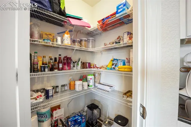 a utility room with lots of clutter and refrigerator