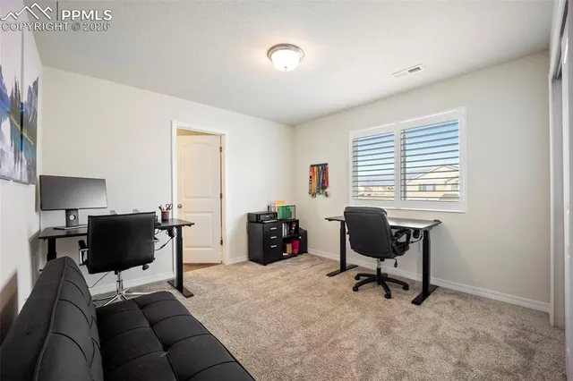 a view of a livingroom with workspace and a window