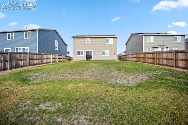 a view of a house with a yard and sitting area