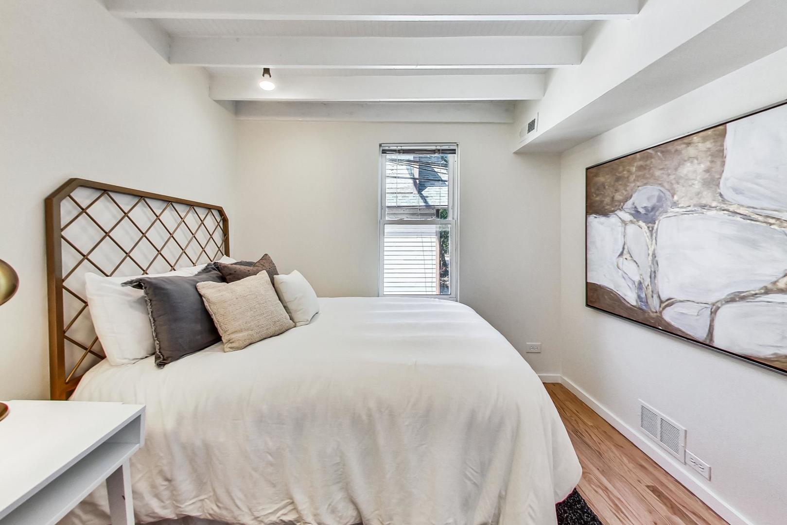 1009 West Wolfram Street, Unit 2W Chicago, IL 60657 - Photo 11 of 24 a large bed sitting in a bedroom next to a window