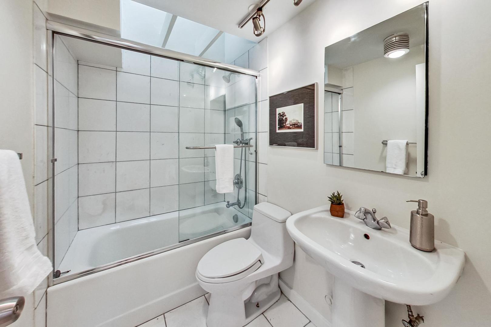 1009 West Wolfram Street, Unit 2W Chicago, IL 60657 - Photo 13 of 24 a bathroom with a sink toilet and shower