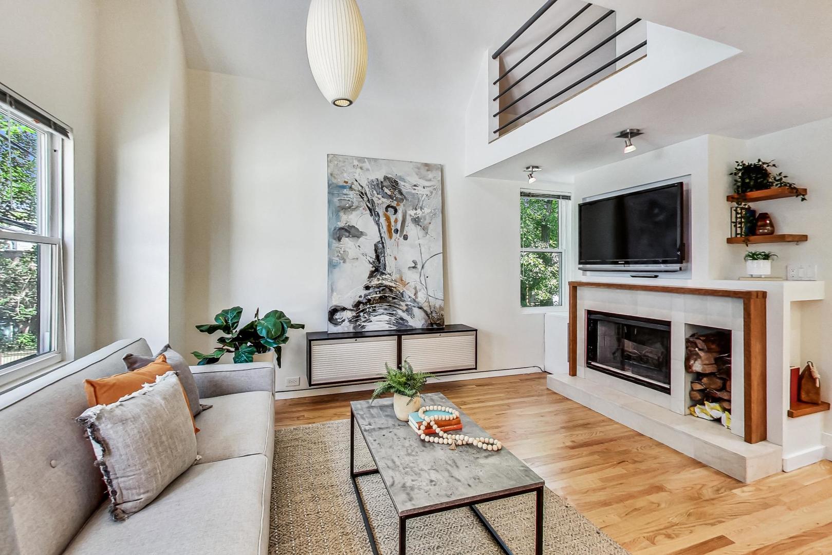 1009 West Wolfram Street, Unit 2W Chicago, IL 60657 - Photo 7 of 24 a living room with furniture a flat screen tv and a fireplace