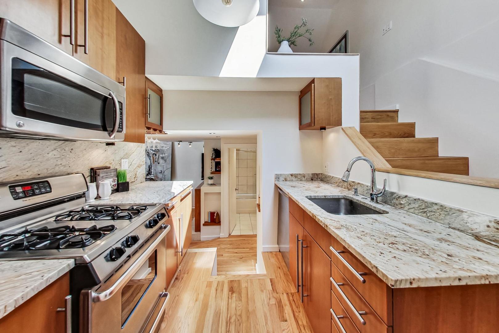 1009 West Wolfram Street, Unit 2W Chicago, IL 60657 - Photo 9 of 24 a kitchen with stainless steel appliances granite countertop a sink stove and refrigerator