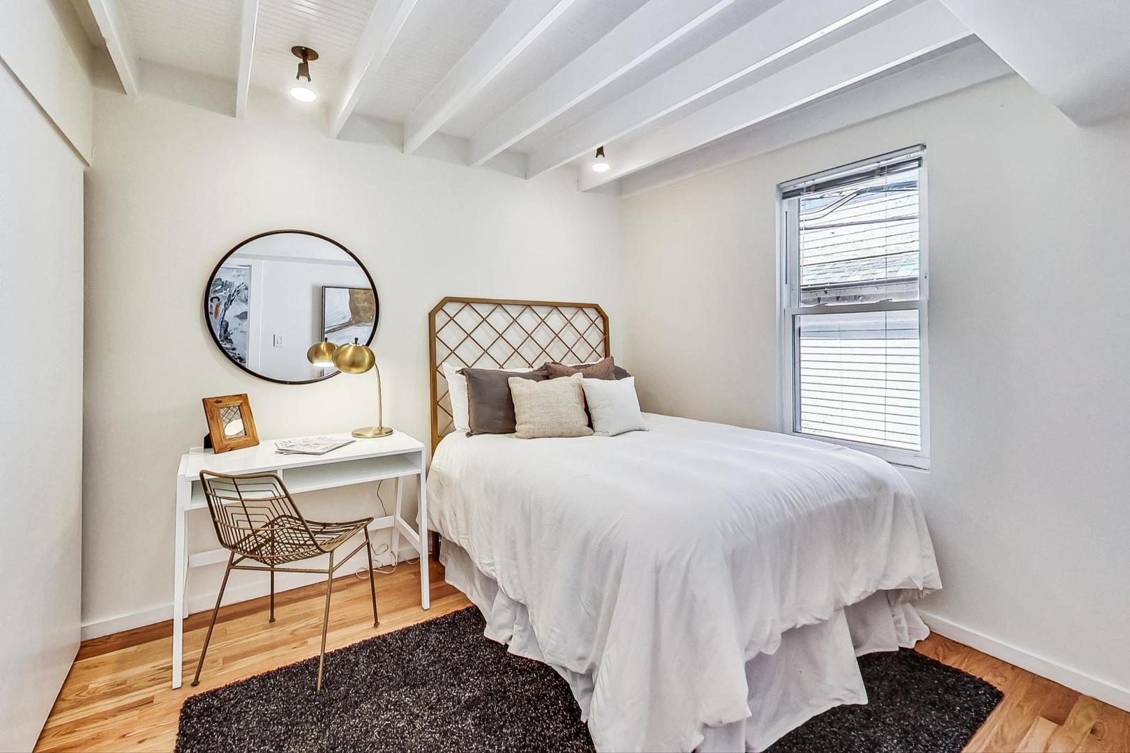 1009 West Wolfram Street, Unit 2W Chicago, IL 60657 - Photo 10 of 24 a bedroom with a bed a mirror and chair