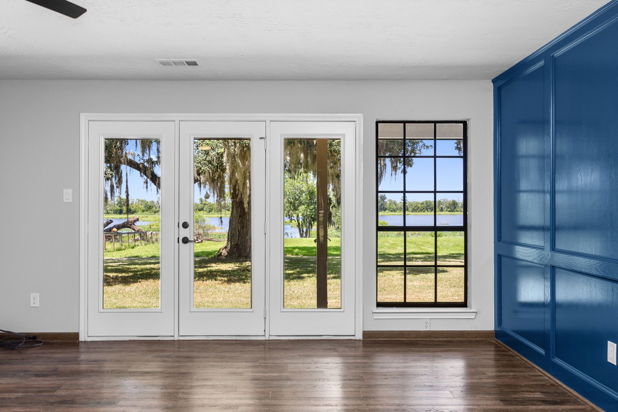 21802 Lake View Road Damon, TX 77430 - Photo 29 of 49 French doors frame picturesque views of the backyard, where towering oaks and the lake create a breathtaking backdrop.