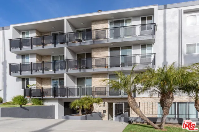 a front view of a building with a garden and plants