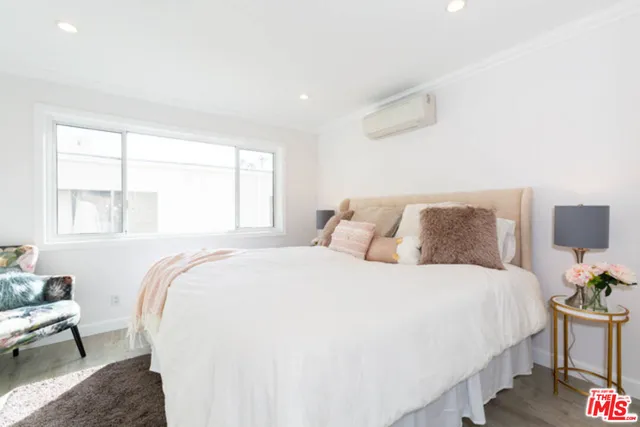 a bedroom with a bed and wooden floor