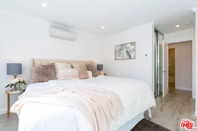 a bedroom with a bed and a painting on the wall