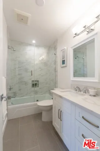 a bathroom with a double vanity sink toilet and shower