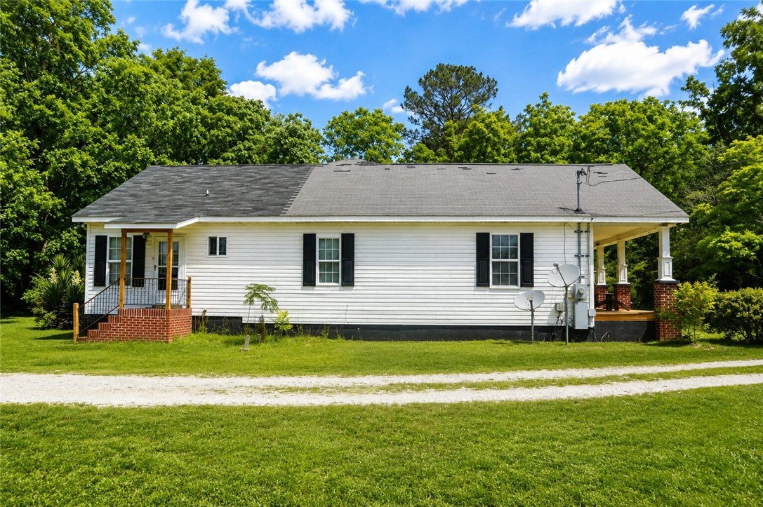 1075 Lowe Road Notasulga, AL 36866 - Photo 2 of 16 This charming residence features a well-maintained exterior, offering a blend of comfort and natural surroundings.