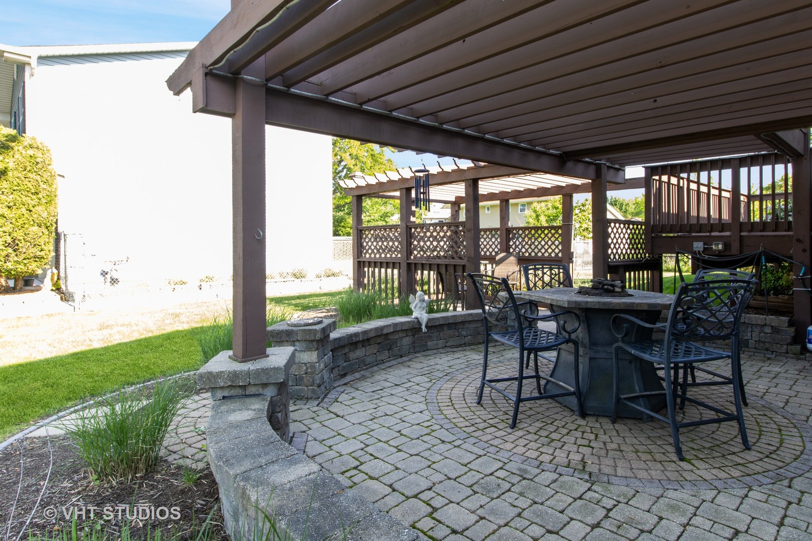 1061 Warwick Circle North Hoffman Estates, IL 60169 - Photo 2 of 18 a view of a patio with table and chairs next to a yard with wooden fence