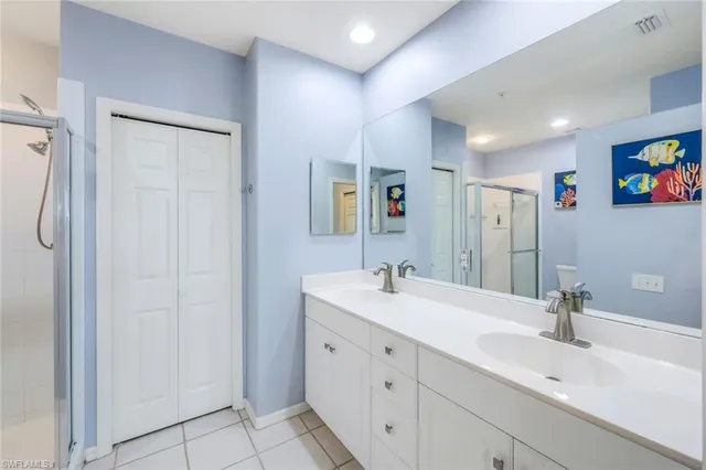 a bathroom with a double vanity sink a mirror and shower