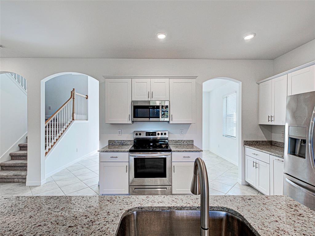 1824 East Isles Rd Port Port Charlotte, FL 33953 - Photo 26 of 80 a kitchen with stainless steel appliances granite countertop a stove a sink and a refrigerator