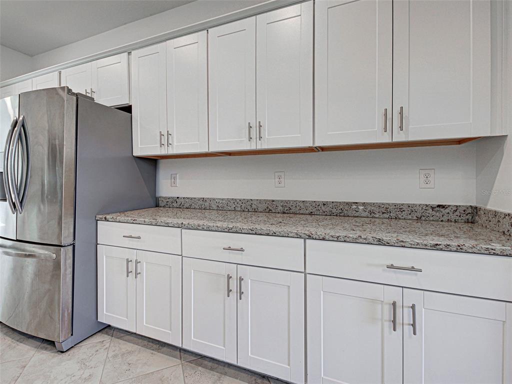 1824 East Isles Rd Port Port Charlotte, FL 33953 - Photo 27 of 80 a kitchen with granite countertop white cabinets and stainless steel appliances
