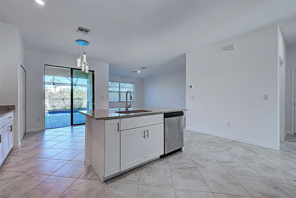 1824 East Isles Rd Port Port Charlotte, FL 33953 - Photo 37 of 80 a large white kitchen with a sink and dishwasher a kitchen island granite top