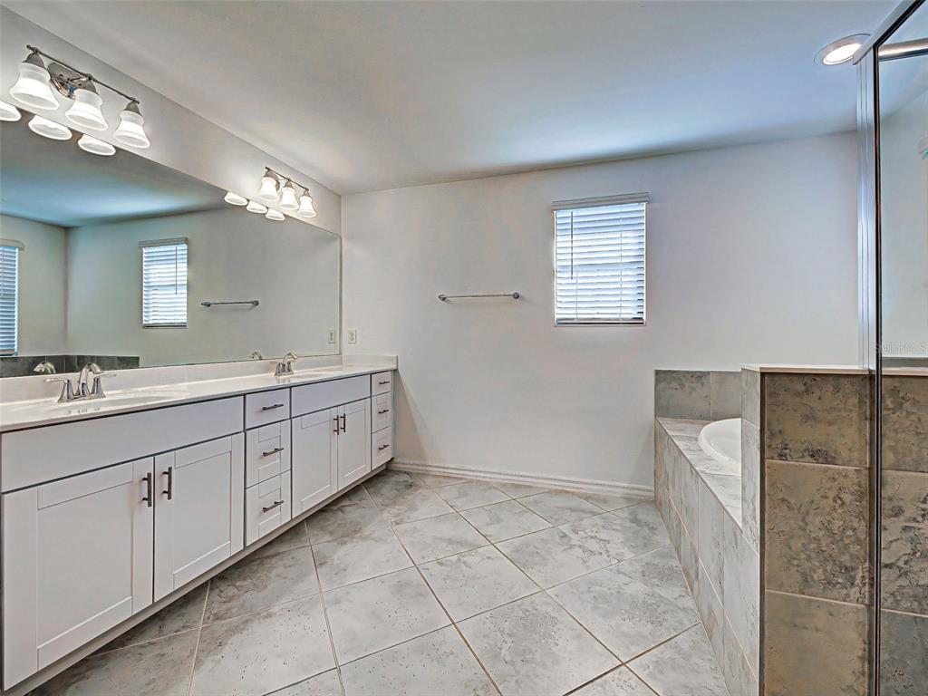 1824 East Isles Rd Port Port Charlotte, FL 33953 - Photo 64 of 80 a spacious bathroom with a double vanity sink a mirror and a shower