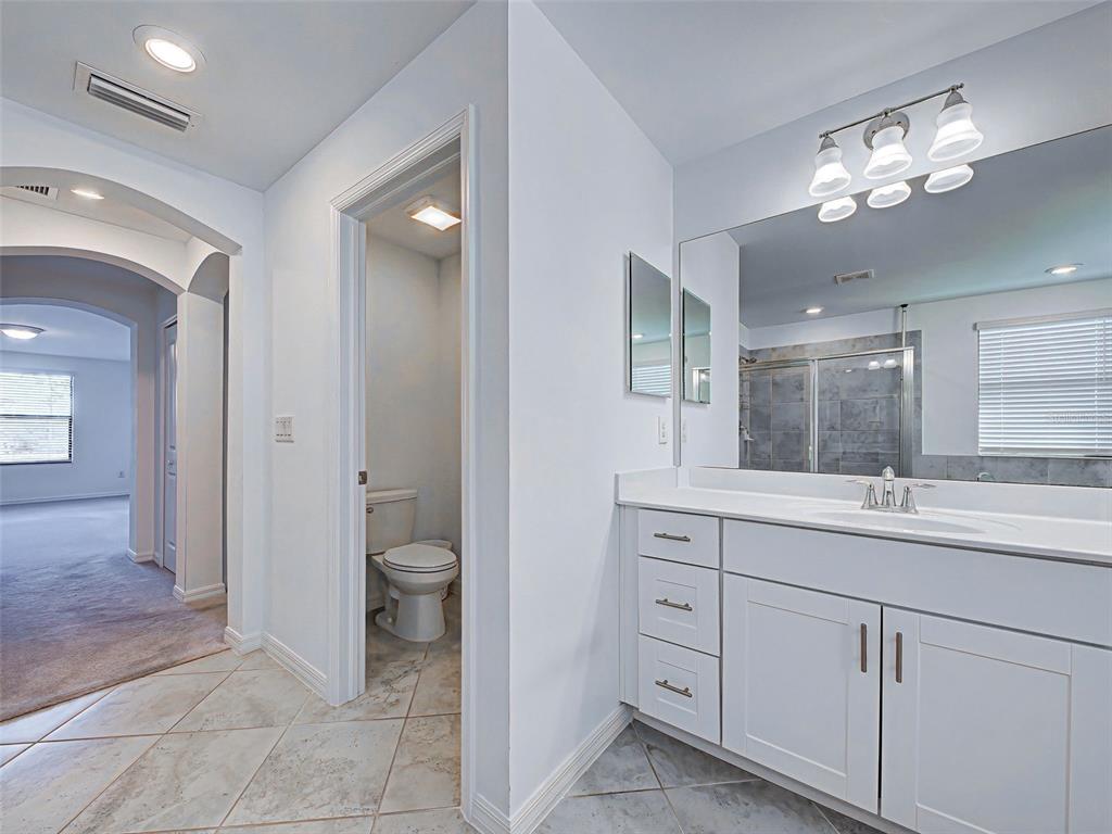 1824 East Isles Rd Port Port Charlotte, FL 33953 - Photo 65 of 80 a spacious bathroom with a granite countertop sink a toilet and a mirror