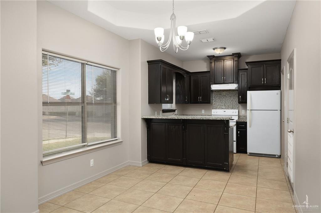 1214 Cornerstone Loop Rio Grande City, TX 78582 - Photo 3 of 15 a view of kitchen with granite countertop cabinets and refrigerator