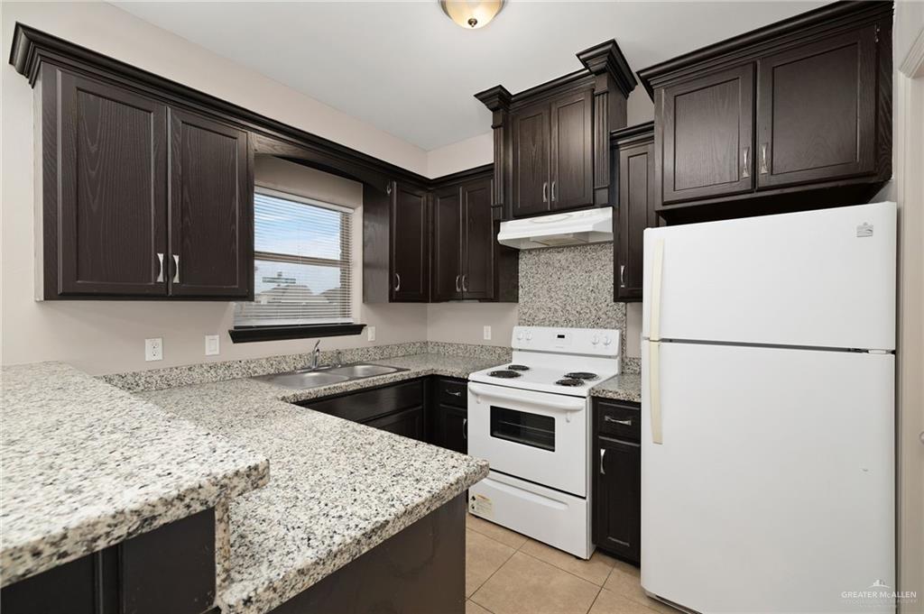 1214 Cornerstone Loop Rio Grande City, TX 78582 - Photo 4 of 15 a kitchen with granite countertop a refrigerator stove and sink