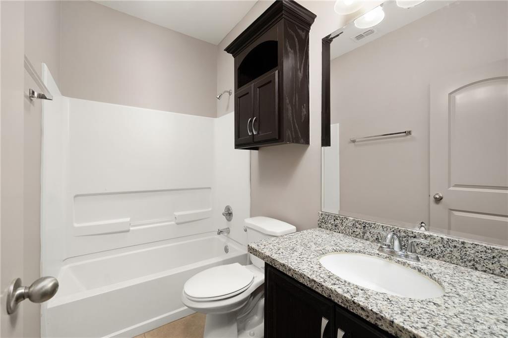 1214 Cornerstone Loop Rio Grande City, TX 78582 - Photo 7 of 15 a bathroom with a granite countertop sink toilet and mirror