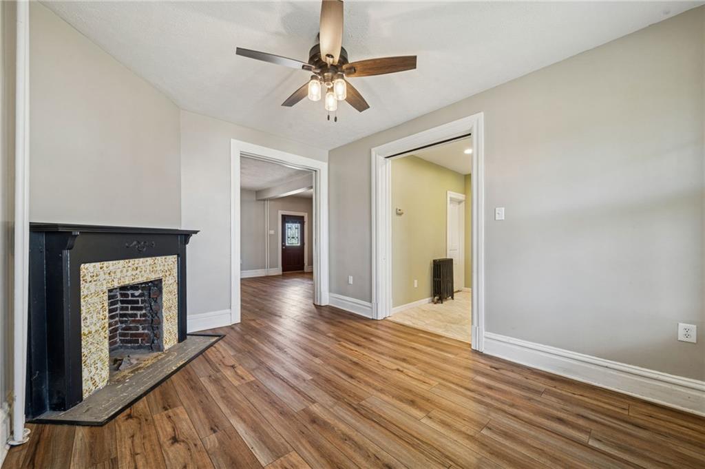 147 Hamilton Avenue Vandergrift, PA 15690 - Photo 12 of 32 wooden floor in an empty room with a fireplace
