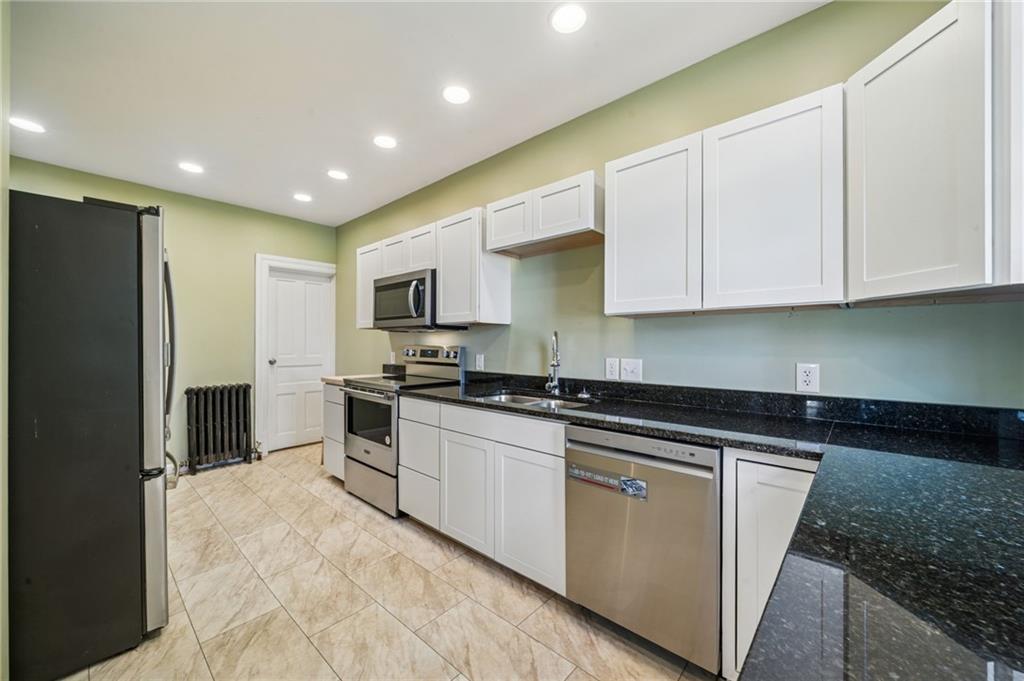 147 Hamilton Avenue Vandergrift, PA 15690 - Photo 16 of 32 a kitchen with stainless steel appliances granite countertop a stove a sink and a refrigerator