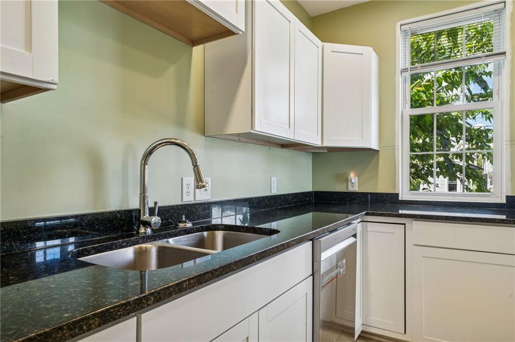 147 Hamilton Avenue Vandergrift, PA 15690 - Photo 17 of 32 a kitchen with granite countertop a sink a counter top space and cabinets