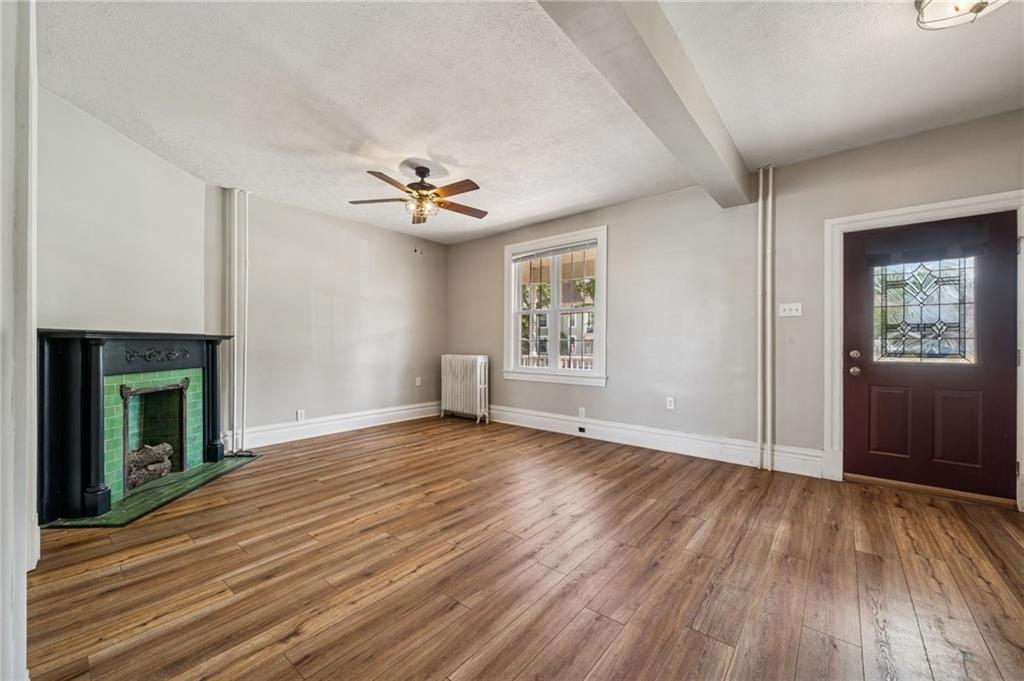 147 Hamilton Avenue Vandergrift, PA 15690 - Photo 8 of 32 an empty room with windows and a fireplace