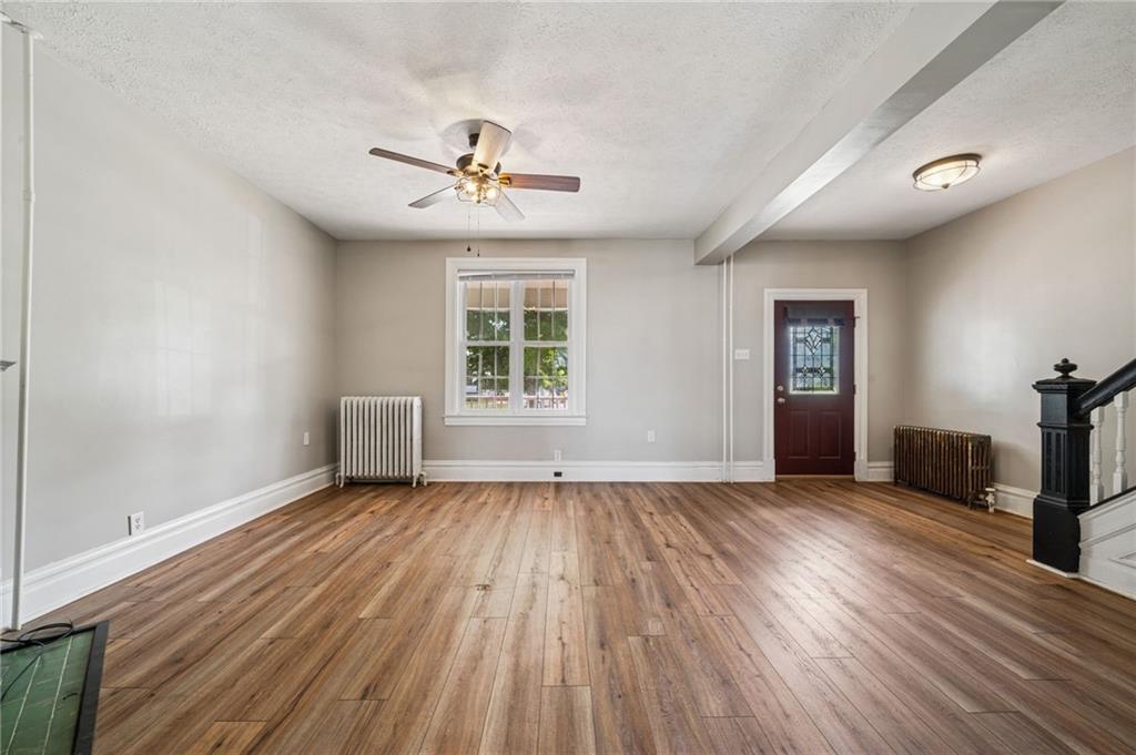 147 Hamilton Avenue Vandergrift, PA 15690 - Photo 10 of 32 a view of an empty room with a window and wooden floor