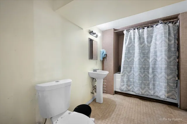 a bathroom with a shower curtain and a toilet