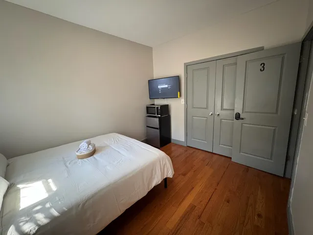 a bedroom with a bed and wooden floor