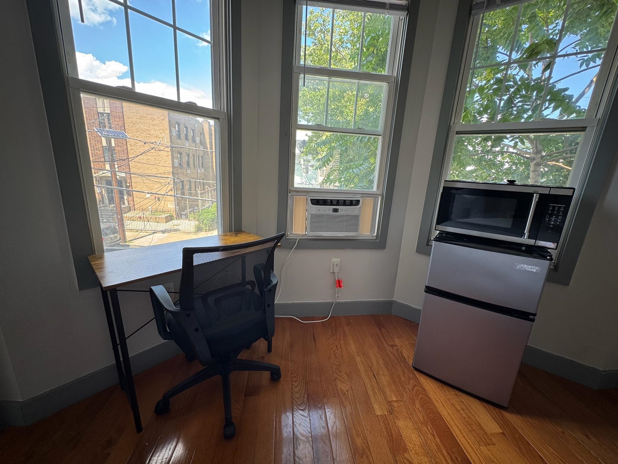 157 Bidwell Avenue, Unit 2 Jersey City, NJ 07305 - Photo 22 of 34 a kitchen with granite countertop wooden floors and stainless steel appliances