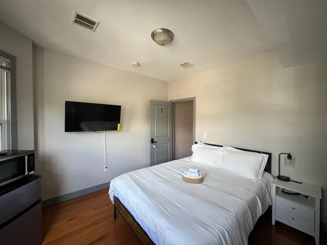 a bedroom with a bed and a flat screen tv