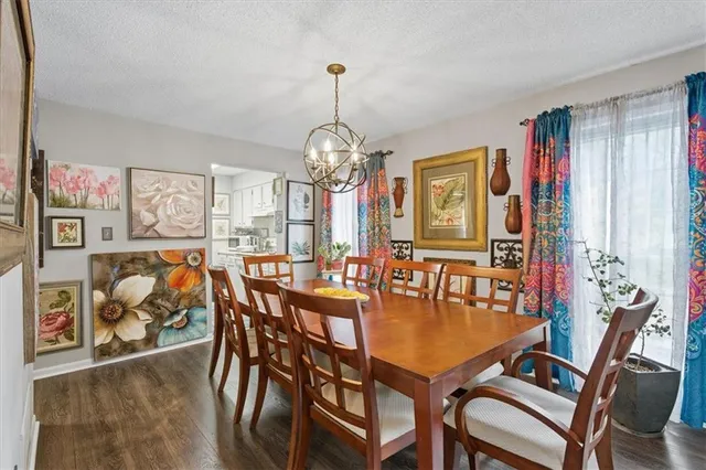 a dining room with furniture a chandelier and wooden floor