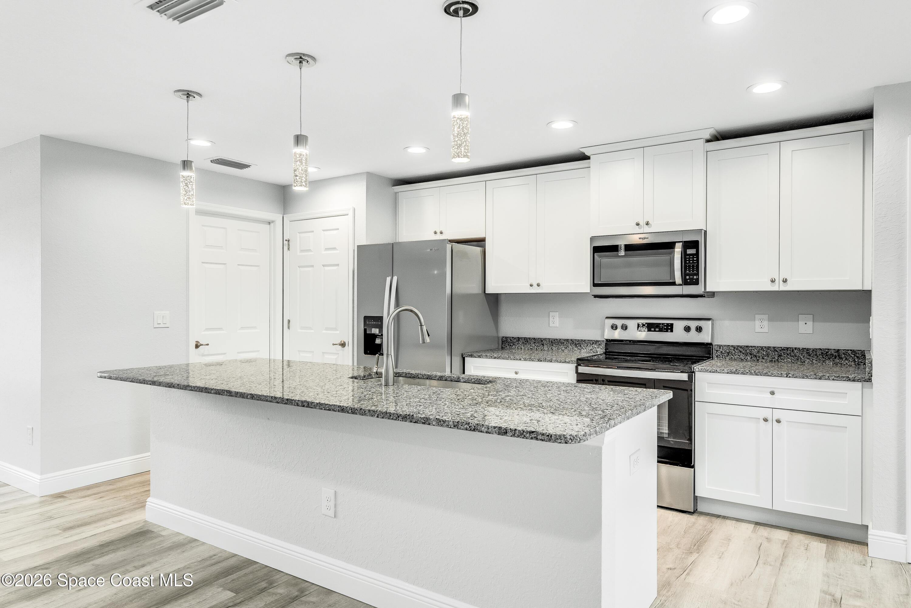 2977 Fig Road Southeast Palm Bay, FL 32909 - Photo 15 of 38 a kitchen with stainless steel appliances granite countertop a sink a stove a refrigerator and cabinets