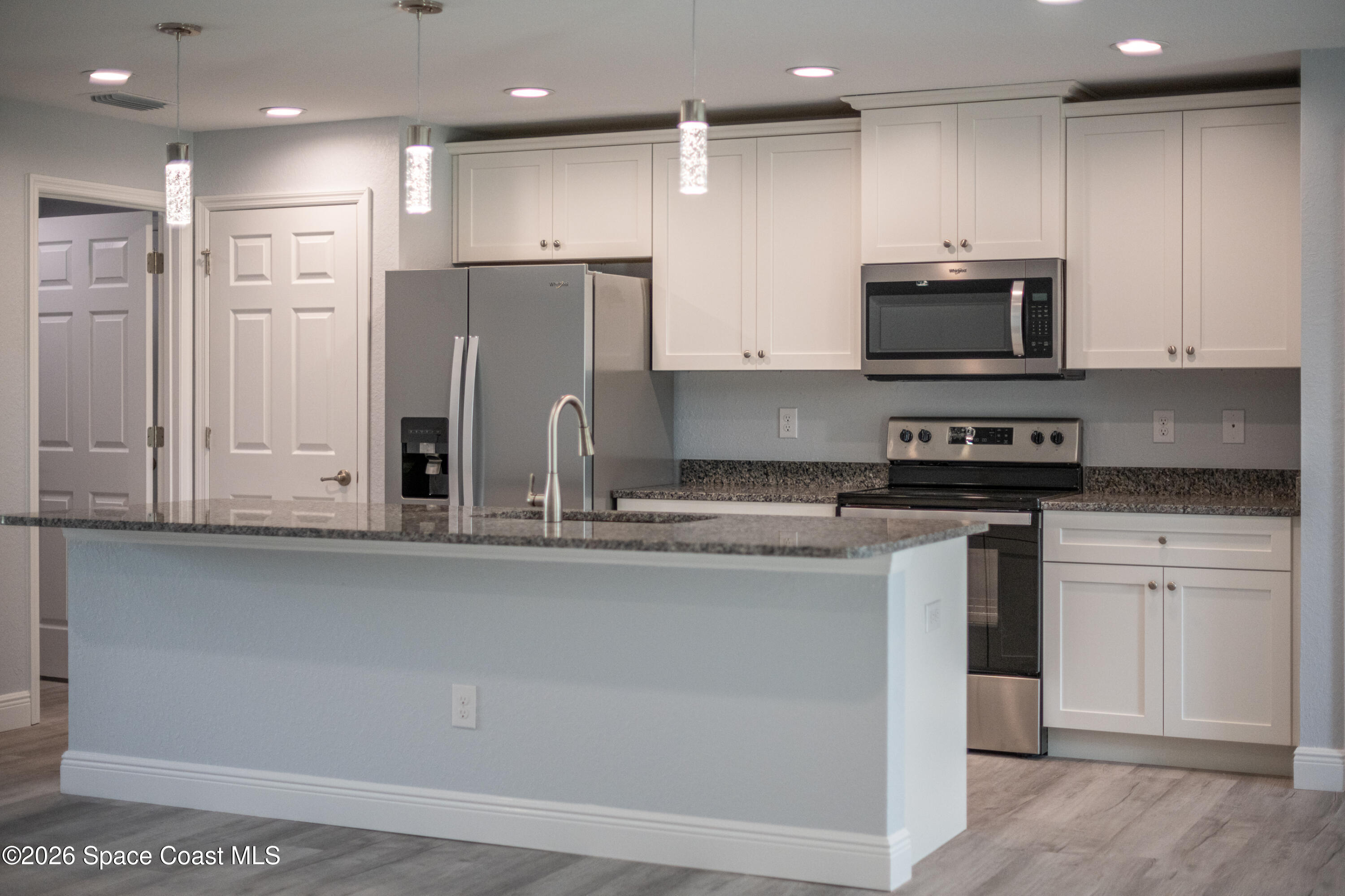 2977 Fig Road Southeast Palm Bay, FL 32909 - Photo 18 of 38 a kitchen with stainless steel appliances granite countertop a refrigerator and a stove top oven