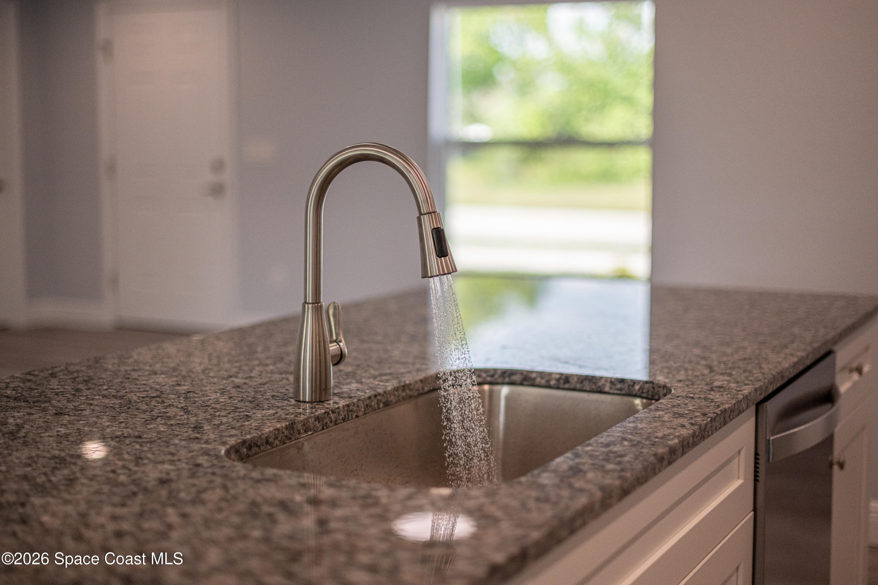 2977 Fig Road Southeast Palm Bay, FL 32909 - Photo 20 of 38 a close view of a faucet a sink and a stove in a bathroom