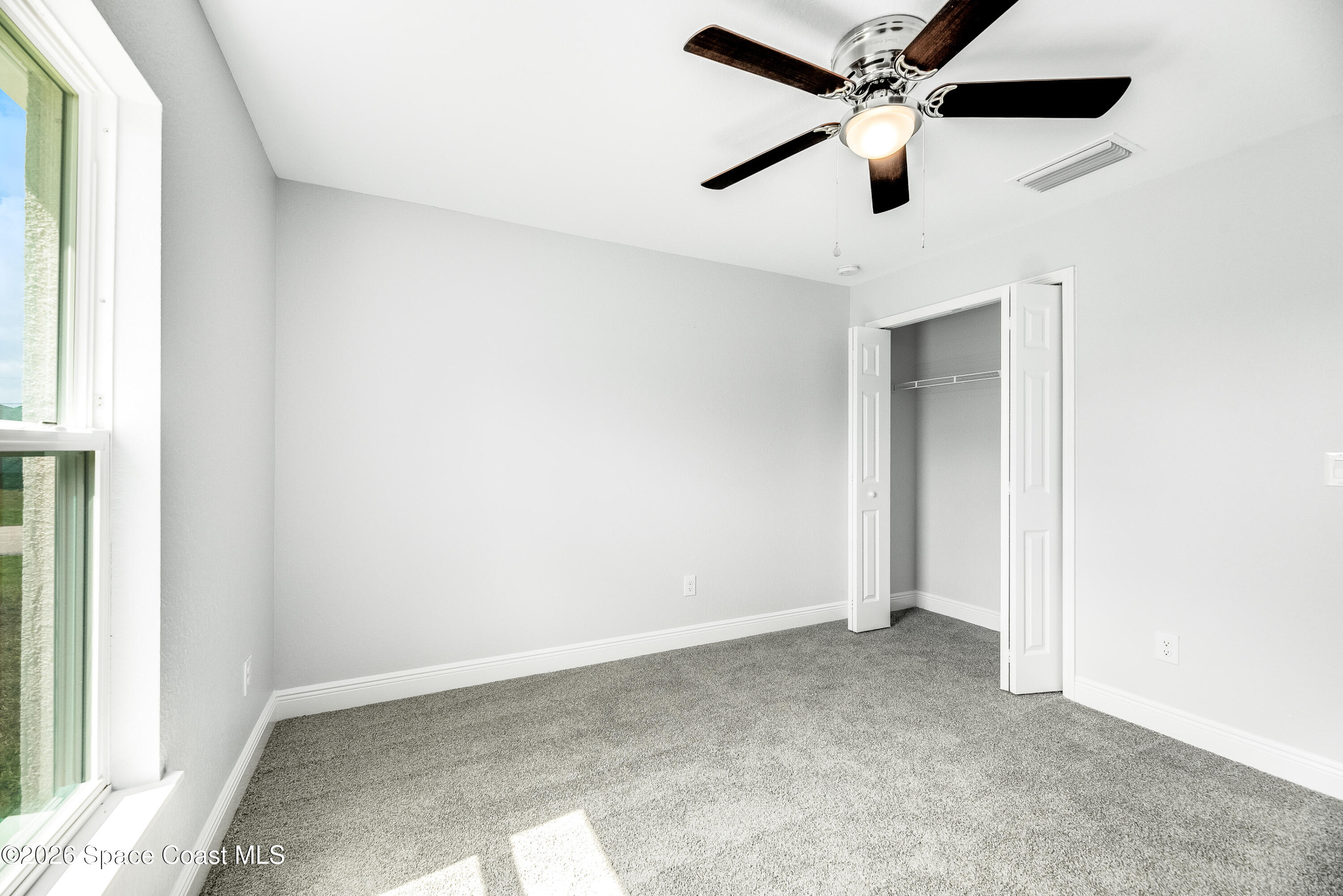 2977 Fig Road Southeast Palm Bay, FL 32909 - Photo 31 of 38 an empty room with a ceiling fan and window