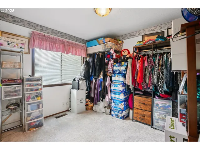 a view of walk in closet with clothes